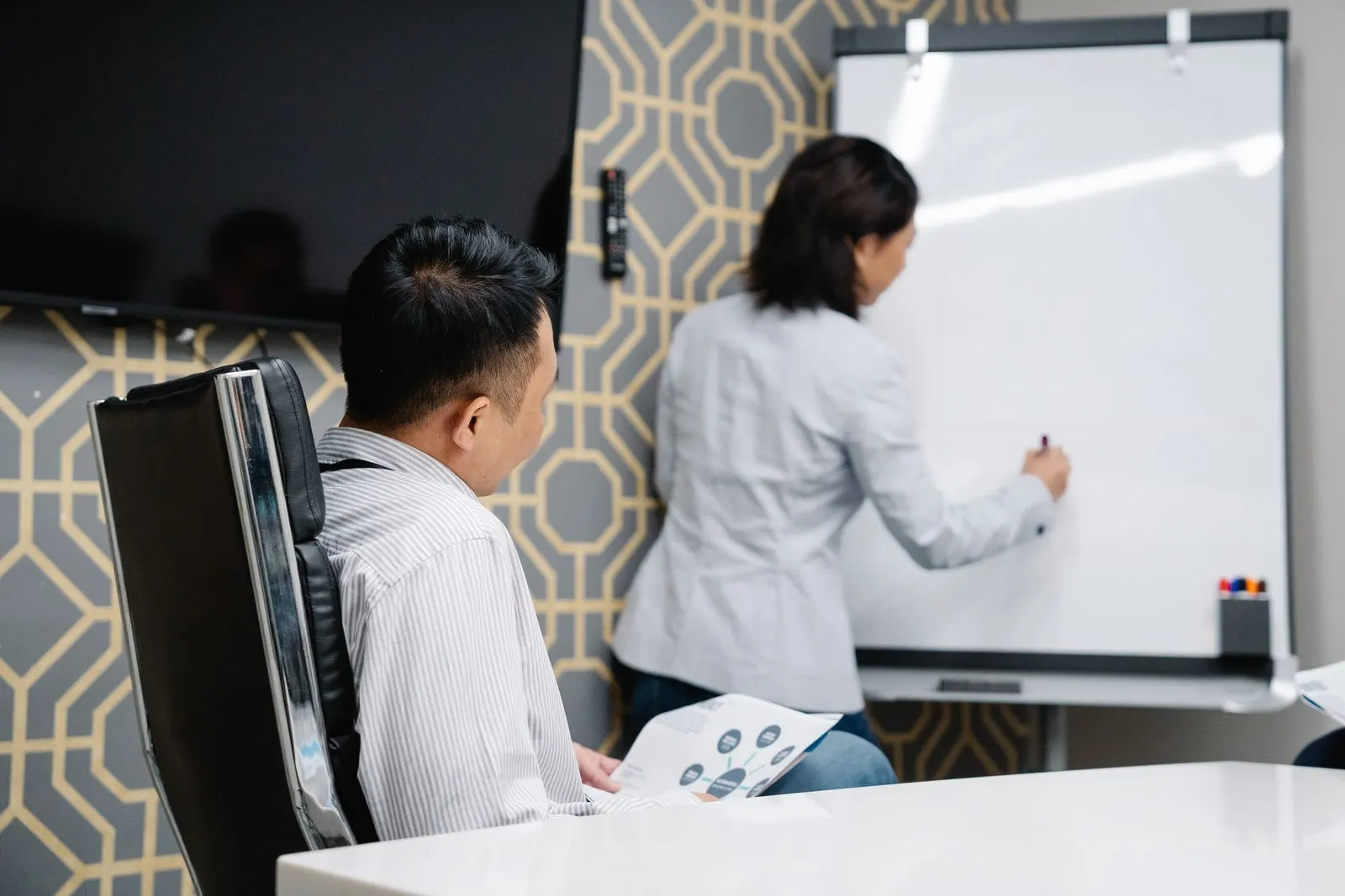 Người hướng dẫn viết lên bảng trắng cho người học